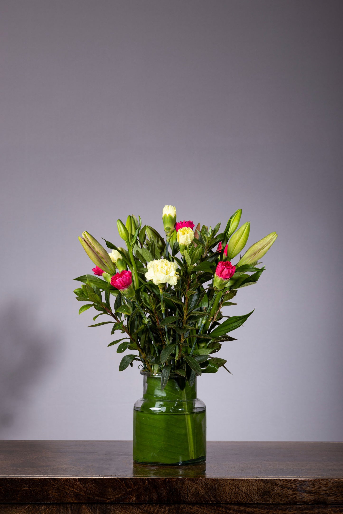 SPRING JOY – Orange Asiatic Lilies & Carnation bouquet in a glass biscuit jar | Flower delivery in Bengaluru | Buy flower bouquets online Bengaluru | Same-day flower delivery Bengaluru | Online florist Bengaluru | Order flowers online Bengaluru