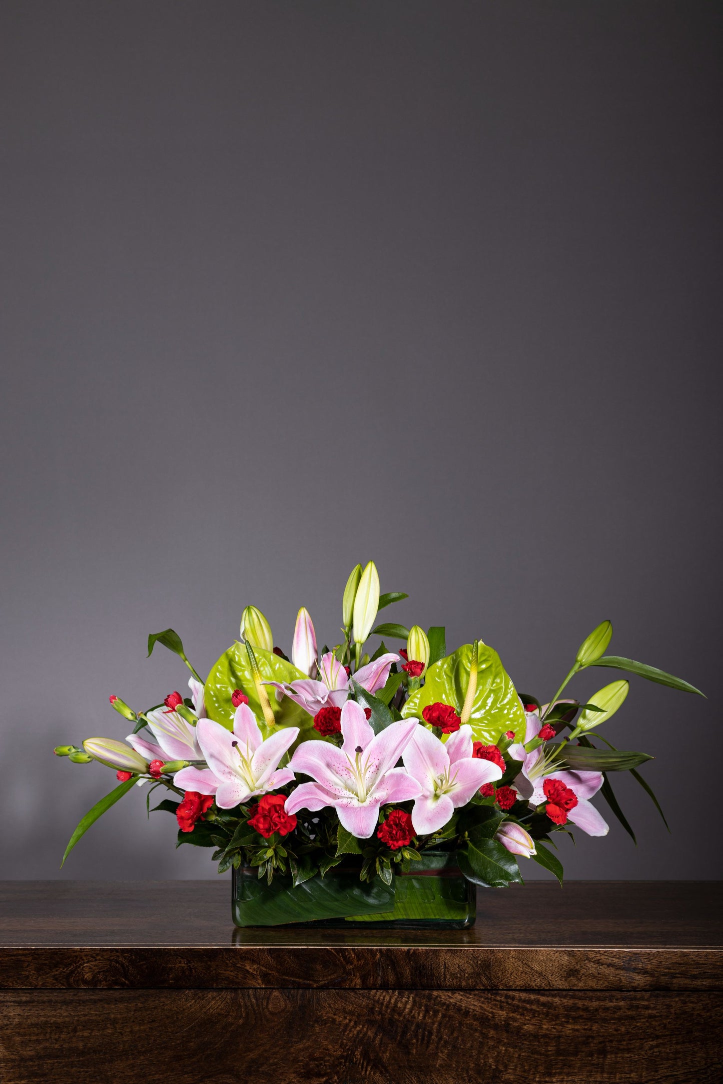 Charming Pinks - Elegant long and low centerpiece with aromatic Oriental Lilies, Spray Carnation, and Eustoma flowers in a glass container | Flower delivery in Bengaluru | Buy flower bouquets online Bengaluru | Same-day flower delivery Bengaluru | Online florist Bengaluru | Order flowers online Bengaluru | Luxury flower bouquet in Bengaluru