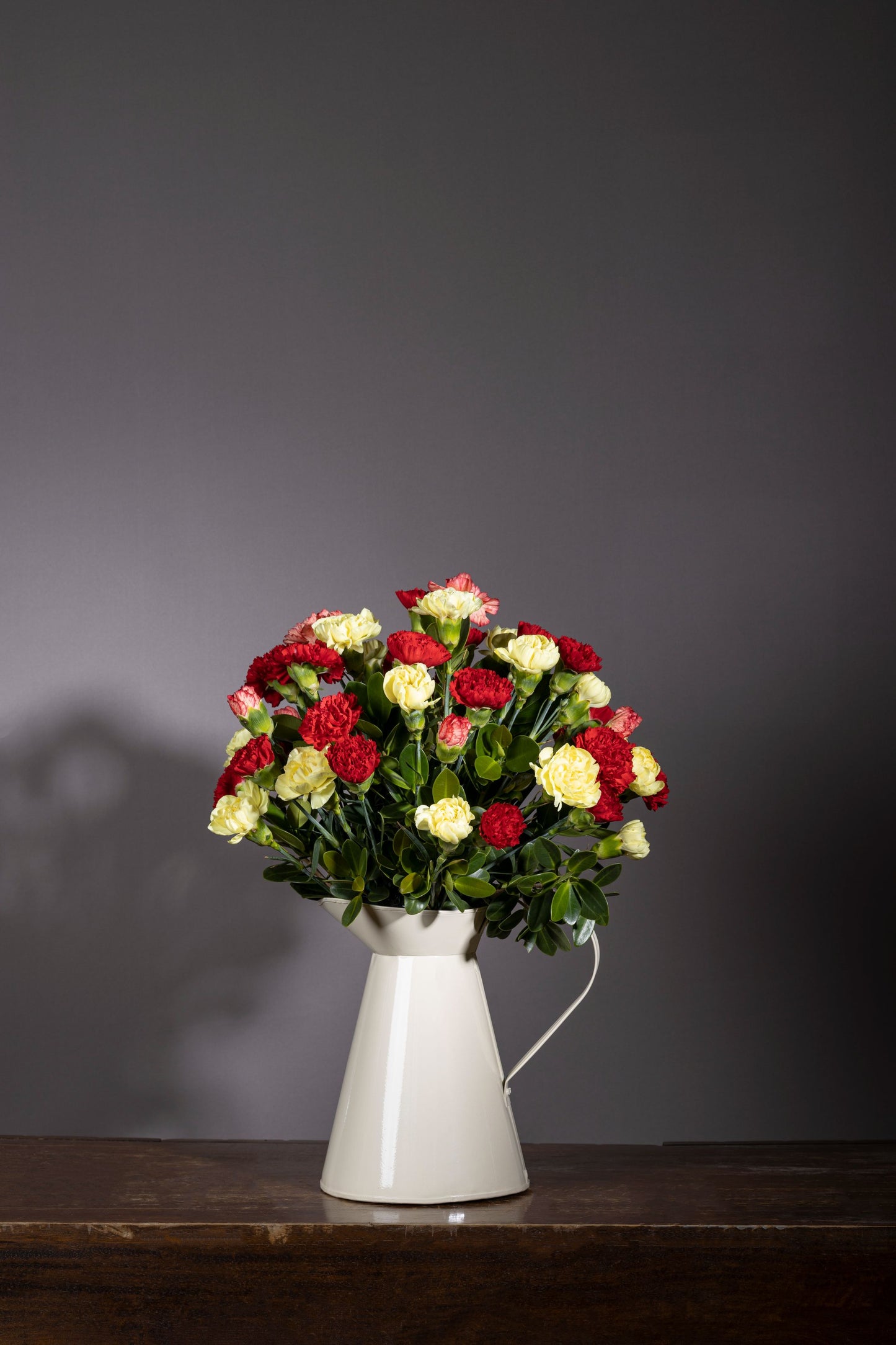 WIZARDRY | Red and yellow Carnations bouquet in white powder-coated tin – Luxury flower bouquet in Bengaluru – Flower delivery in Bengaluru – Buy flower bouquets online Bengaluru – Same-day flower delivery Bengaluru – Online florist Bengaluru – Order flowers online Bengaluru