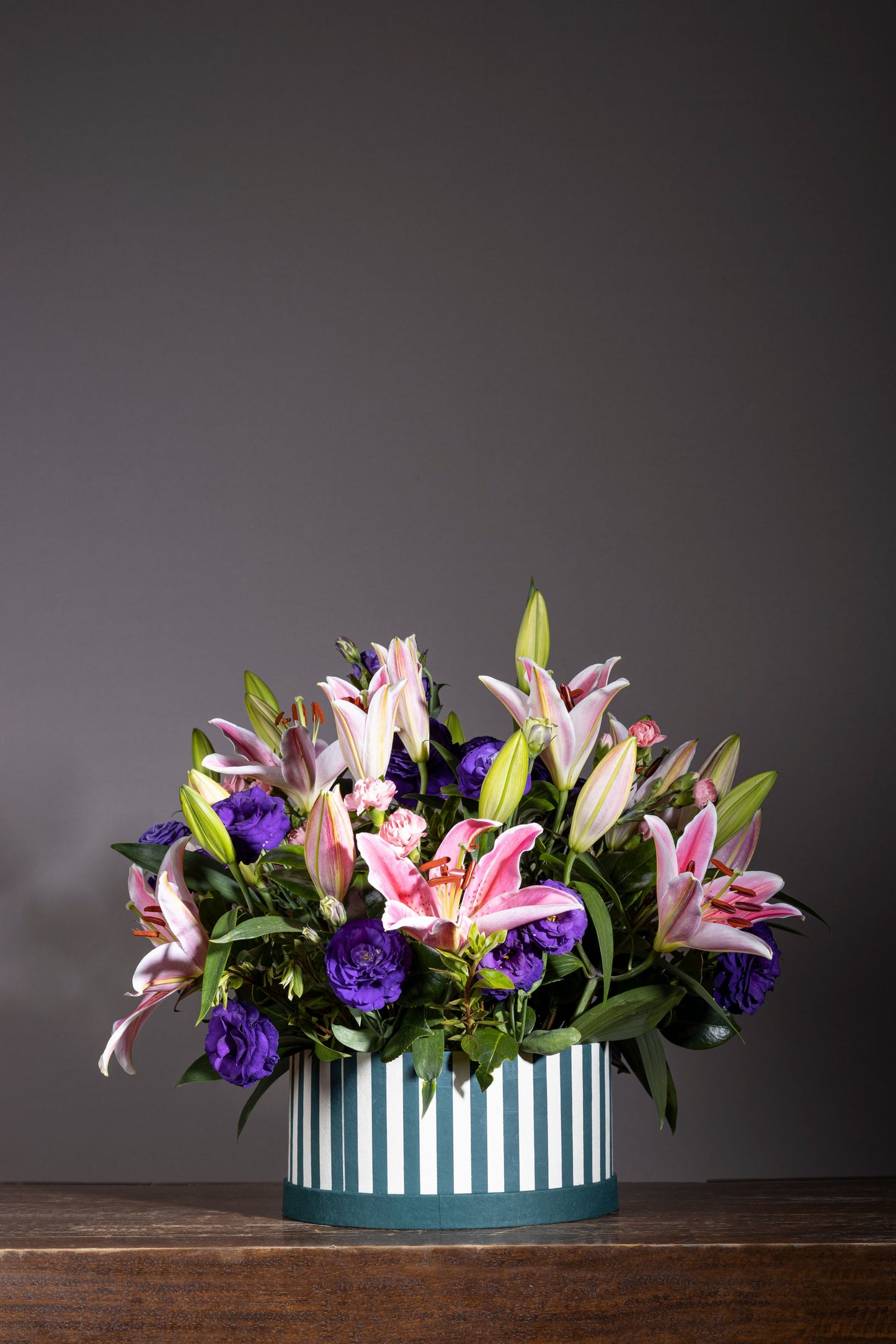 Romantic – A stunning custom keepsake hat box filled with fragrant Pink Oriental Lilies and elegant Purple Lisianthus blooms, complemented by lush foliage. The perfect gift for birthdays, anniversaries, thank you gestures, congratulations, and new baby celebrations