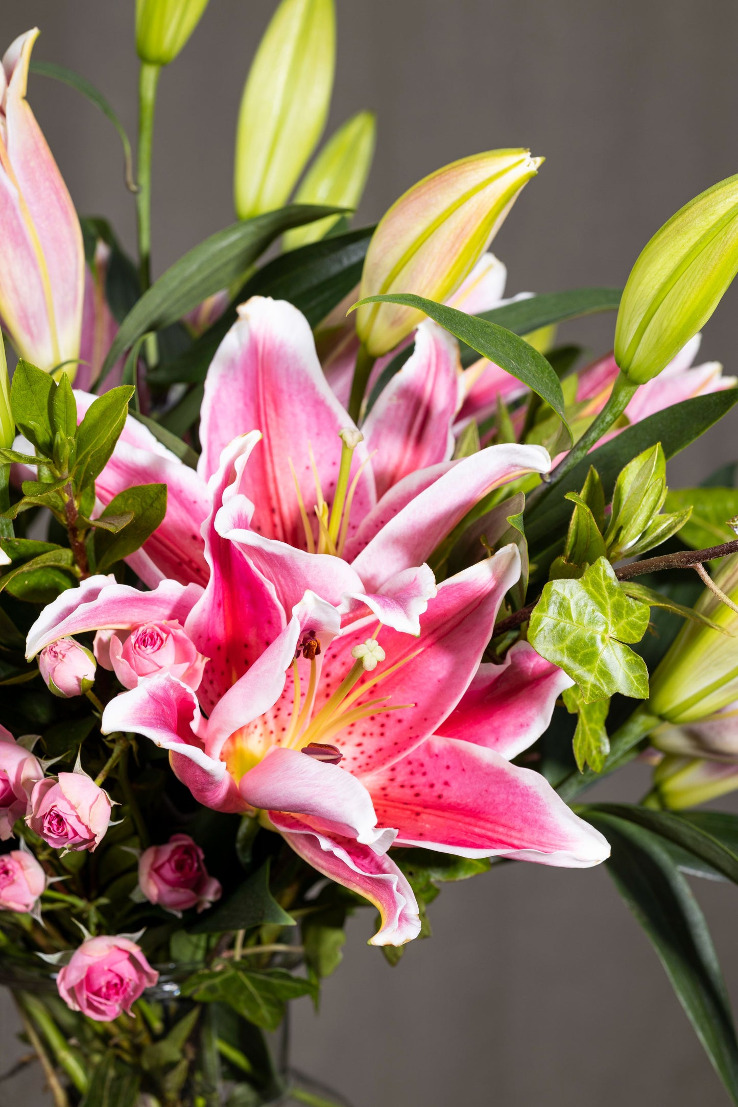 Charmer - Elegant Oriental Lilies and Spray Carnation flowers in a clear glass biscuit jar with lush foliage | Flower delivery in Bengaluru | Buy flower bouquets online Bengaluru | Same-day flower delivery Bengaluru | Online florist Bengaluru | Order flowers online Bengaluru | Luxury flower bouquet in Bengaluru