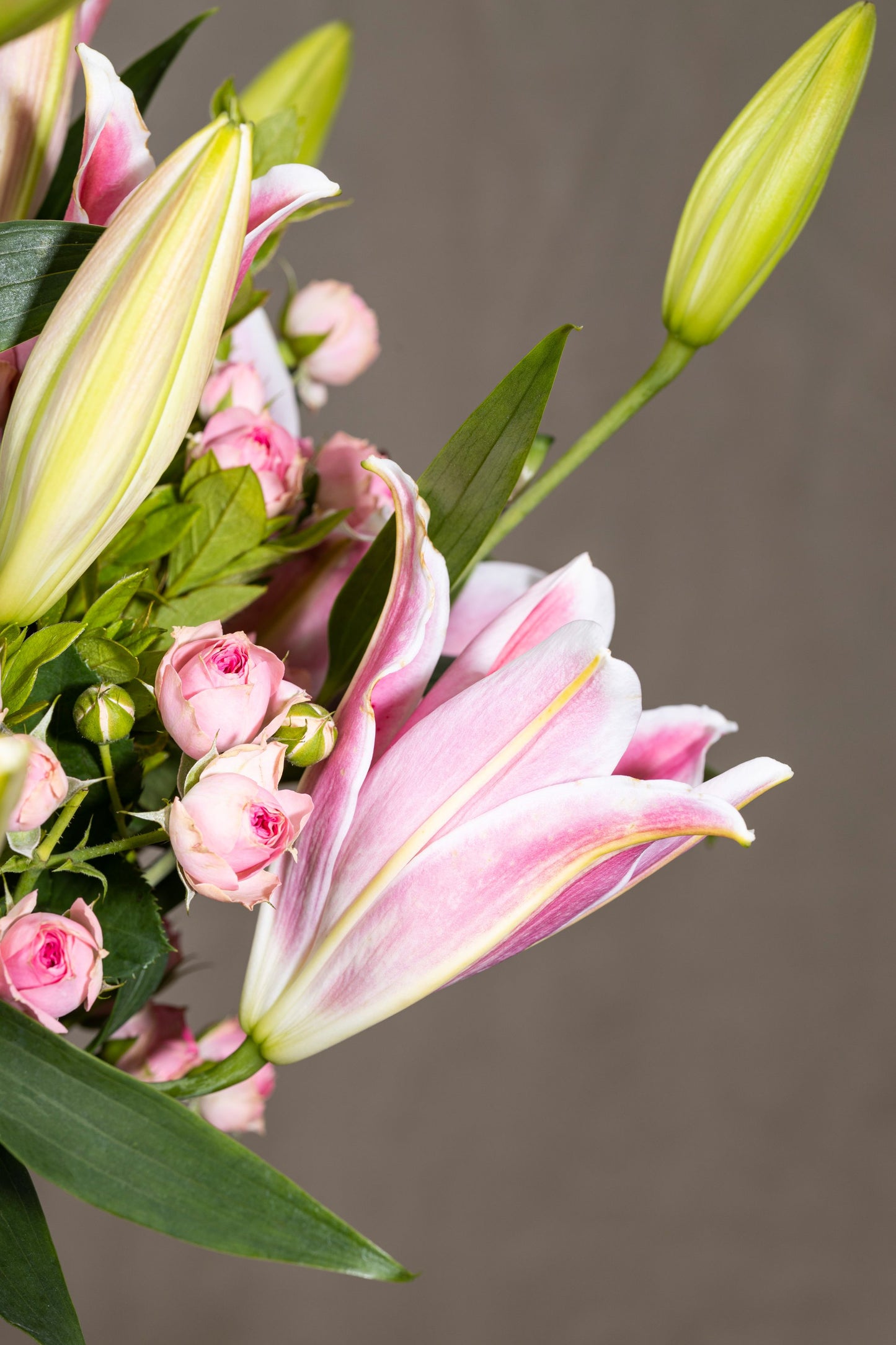 Charmer - Elegant Oriental Lilies and Spray Carnation flowers in a clear glass biscuit jar with lush foliage | Flower delivery in Bengaluru | Buy flower bouquets online Bengaluru | Same-day flower delivery Bengaluru | Online florist Bengaluru | Order flowers online Bengaluru | Luxury flower bouquet in Bengaluru