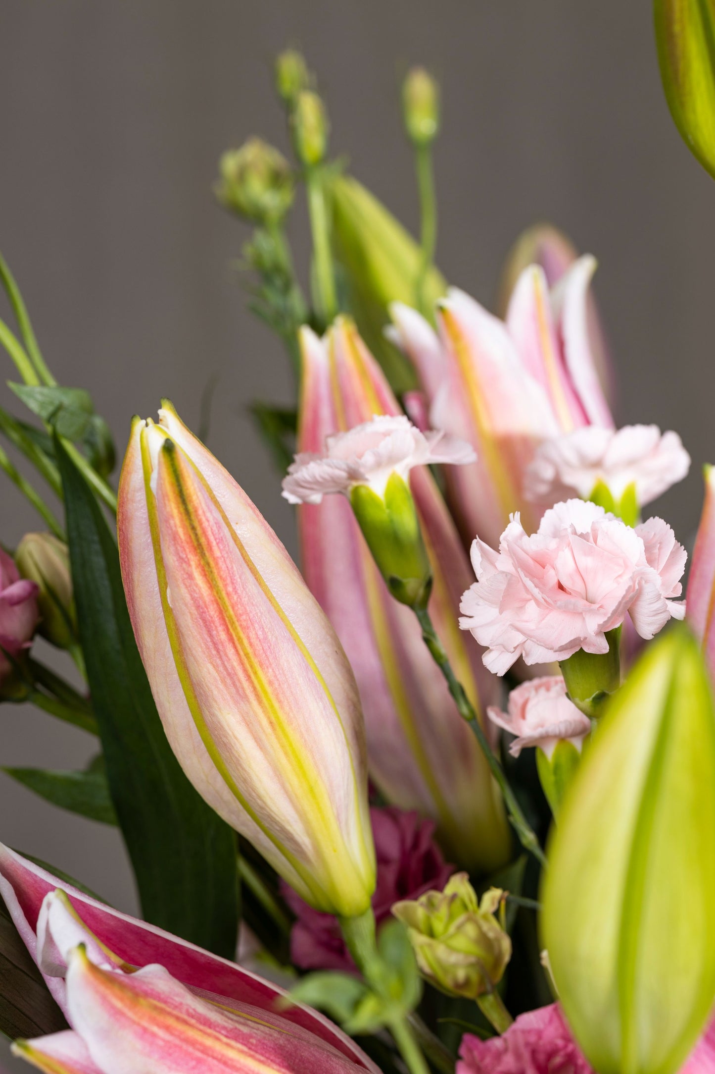 Pink Charming - Elegant glass biscuit jar arrangement with pink Oriental Lilies, aromatic silver dollar eucalyptus sprigs, and Spray Carnation flowers | Flower delivery in Bengaluru | Buy flower bouquets online Bengaluru | Same-day flower delivery Bengaluru | Online florist Bengaluru | Order flowers online Bengaluru | Luxury flower bouquet in Bengaluru