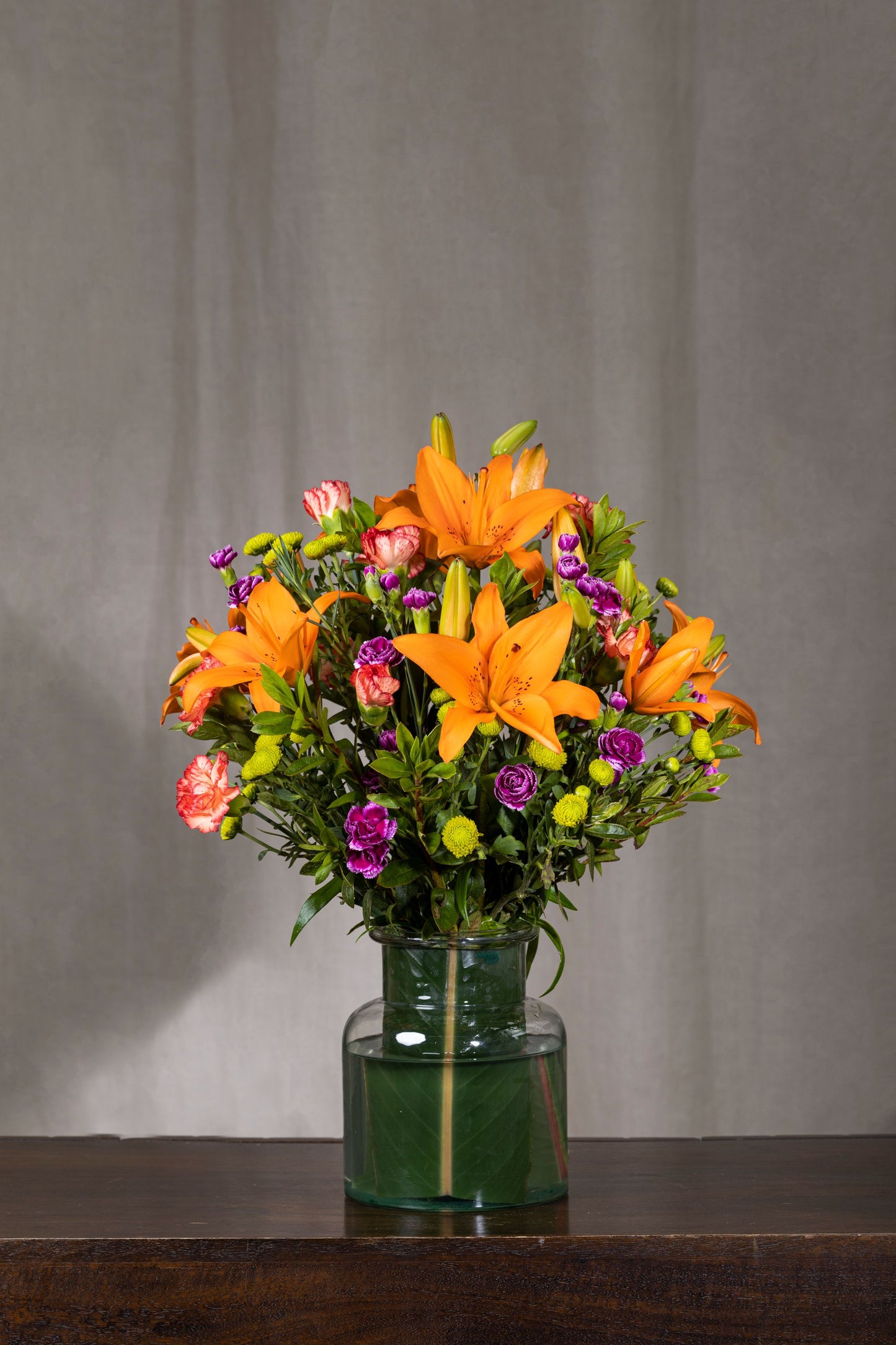 ORANGE SAFARI - A vibrant bouquet featuring Orange Asiatic Lilies, Purple Chrysanthemums, and lush green fillers. Perfect for Birthdays, Anniversaries, Thank You, Congratulations, New Baby, and Condolence occasions. Flower delivery in Bengaluru | Buy flower bouquets online Bengaluru | Same-day flower delivery Bengaluru | Online florist Bengaluru | Order flowers online Bengaluru | Luxury flower bouquet in Bengaluru