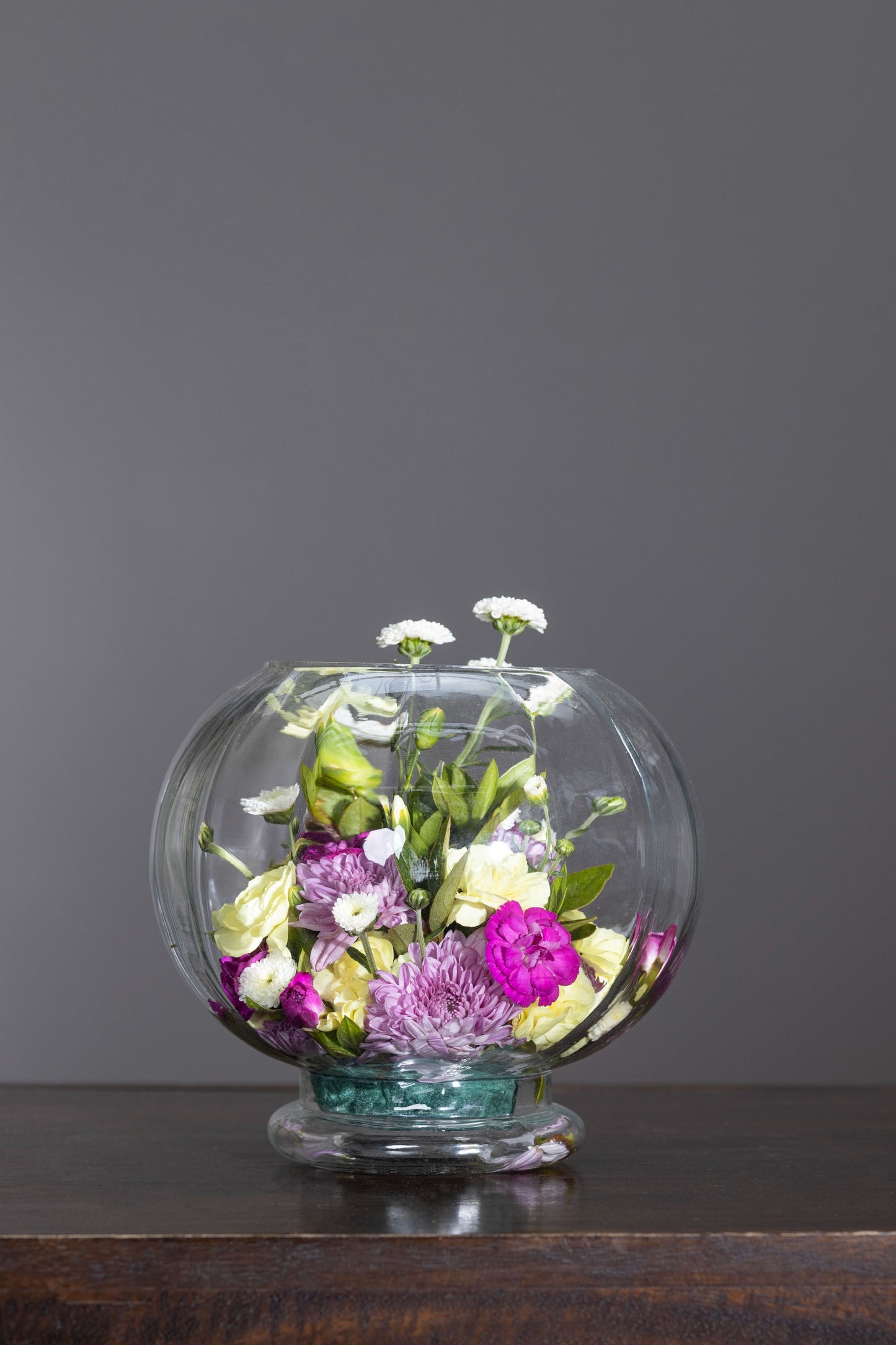 BRILLIANCE - A stunning fish bowl arrangement featuring pink roses and a mix of vibrant blossoms to brighten any space. Perfect for Birthdays, Anniversaries, Thank You, Congratulations, New Baby, and Condolence. Flower delivery in Bengaluru, Buy flower bouquets online in Bengaluru, Same-day flower delivery Bengaluru, Online florist Bengaluru, Order flowers online Bengaluru, Luxury flower bouquet in Bengaluru