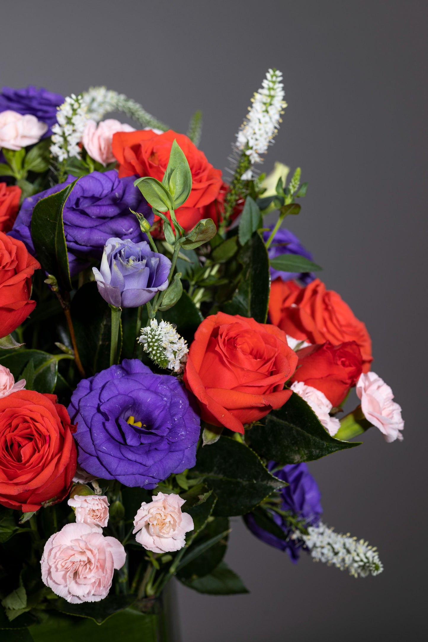 SPRING MELODY - A beautifully arranged leaf-lined cylindrical glass vase featuring pink Roses or Carnations, Purple Eustomas, and Spray Carnation stalks, creating a harmonious floral melody. Perfect for Birthdays, Anniversaries, Thank You, Congratulations, and New Baby. Flower delivery in Bengaluru, Buy flower bouquets online in Bengaluru, Same-day flower delivery Bengaluru, Online florist Bengaluru, Order flowers online Bengaluru, Luxury flower bouquet in Bengaluru.