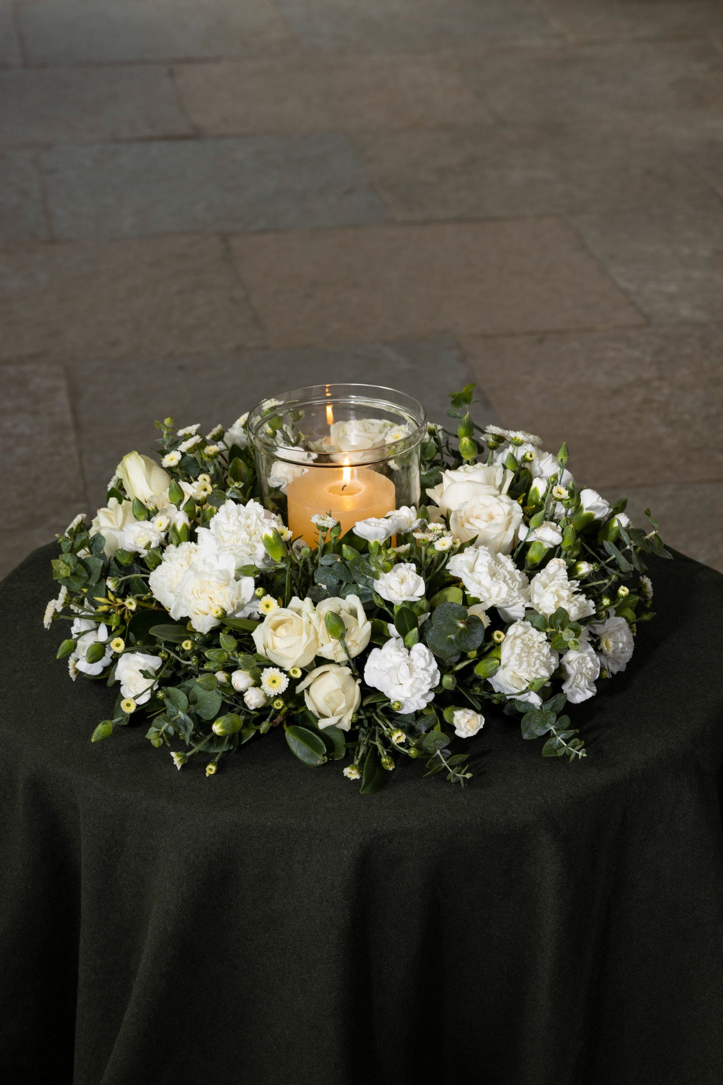 CIRCLE OF SIMPLICITY - A serene and elegant wreath of white flowers, including Carnations, Chrysanthemums, and seasonal favorites, accompanied by a candle for a peaceful touch. Perfect for Birthdays, Anniversaries, Thank You, Congratulations, New Baby, and Condolence. Flower delivery in Bengaluru, Buy flower bouquets online in Bengaluru, Same-day flower delivery Bengaluru, Online florist Bengaluru, Order flowers online Bengaluru, Luxury flower bouquet in Bengaluru