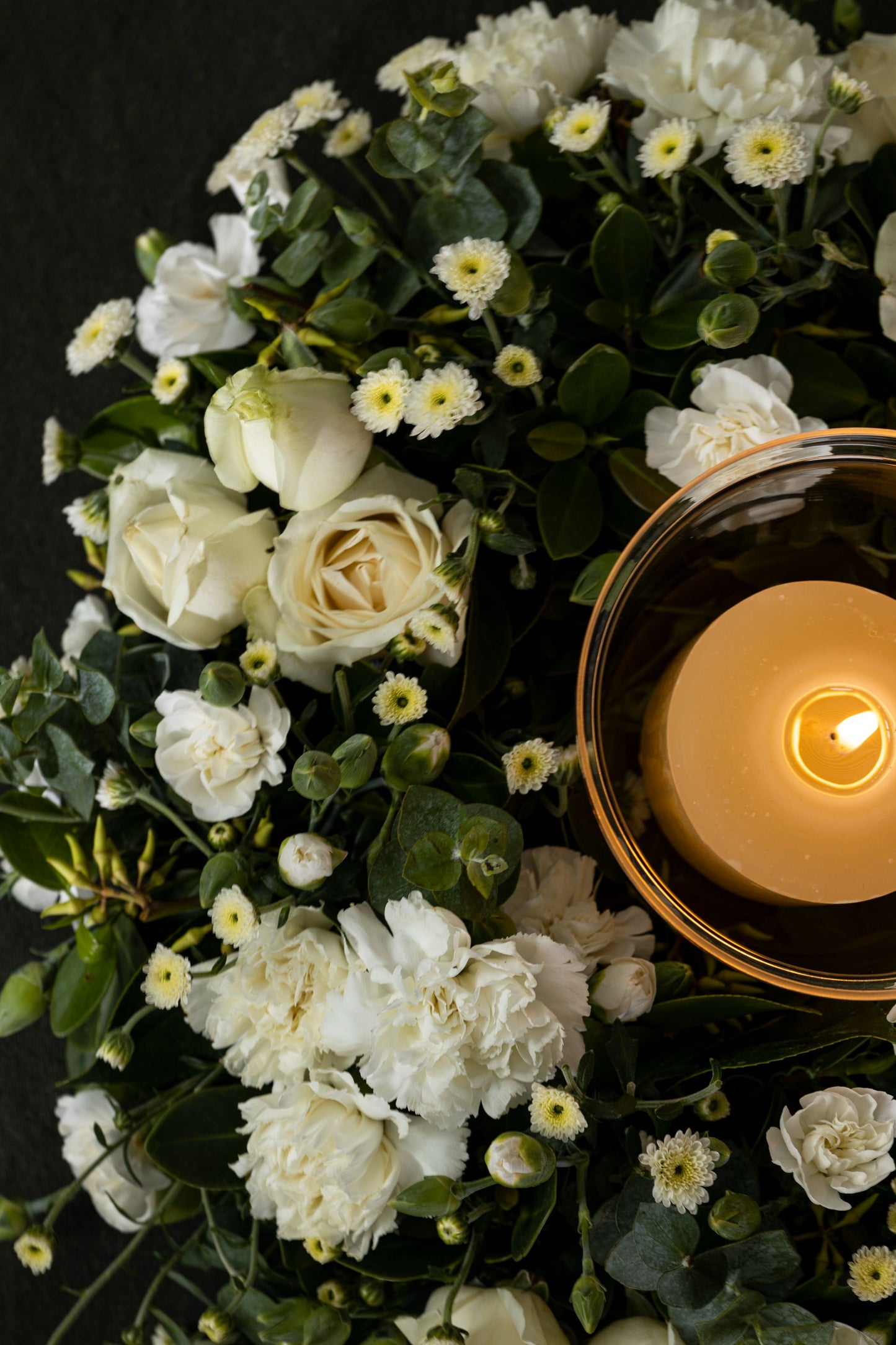 CIRCLE OF SIMPLICITY - A serene and elegant wreath of white flowers, including Carnations, Chrysanthemums, and seasonal favorites, accompanied by a candle for a peaceful touch. Perfect for Birthdays, Anniversaries, Thank You, Congratulations, New Baby, and Condolence. Flower delivery in Bengaluru, Buy flower bouquets online in Bengaluru, Same-day flower delivery Bengaluru, Online florist Bengaluru, Order flowers online Bengaluru, Luxury flower bouquet in Bengaluru