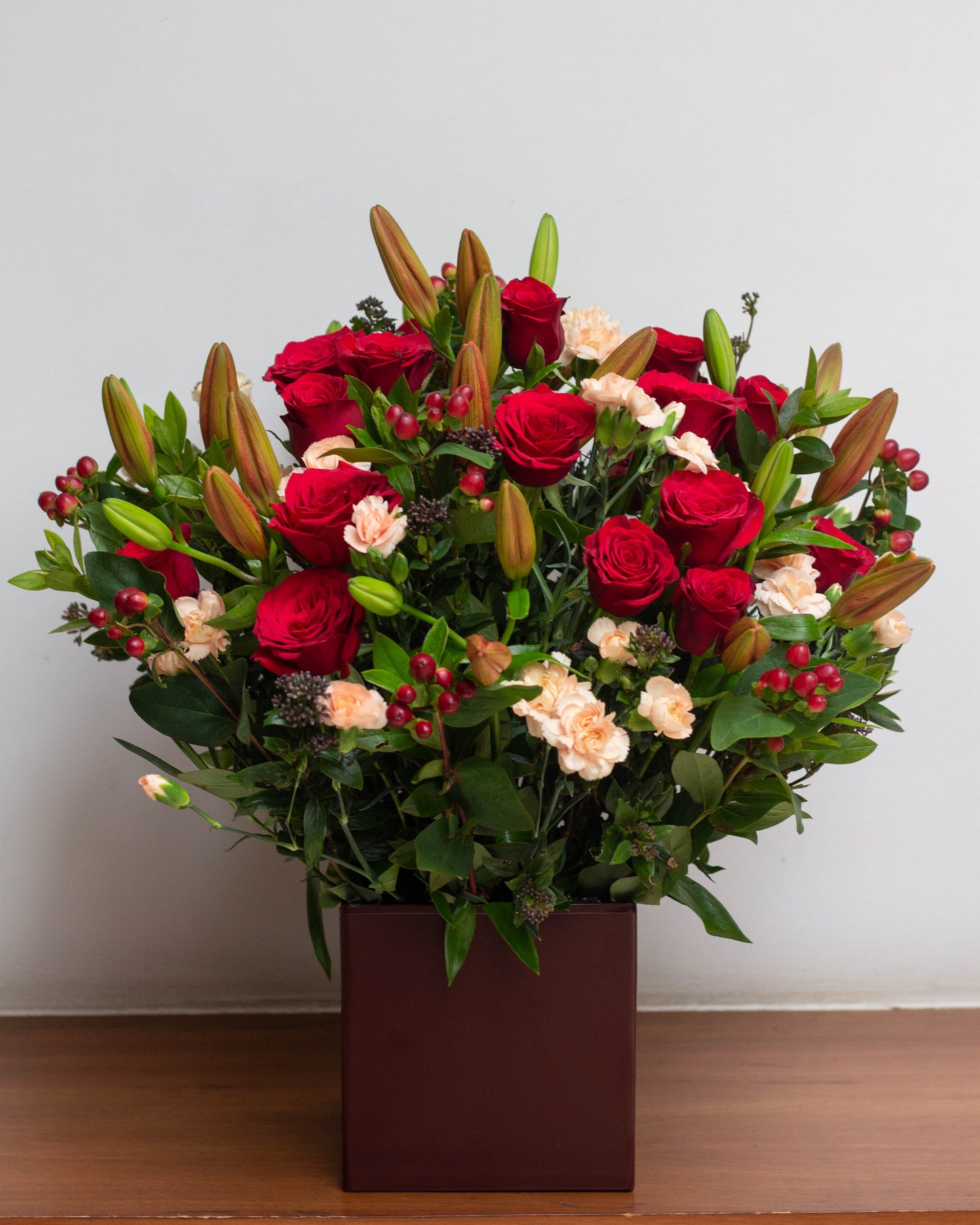 I AM ON FIRE – A passionate floral arrangement featuring deep Red Lilies, bright Red Roses, Peach Spray Carnations, and Red Hypericum berries in a beautiful square tin. Perfect for Valentine’s Day, birthdays, anniversaries, congratulations, new baby celebrations, and thank you gifts. Flower delivery in Bengaluru | Buy flower bouquets online Bengaluru | Same-day flower delivery Bengaluru | Online florist Bengaluru | Order flowers online Bengaluru | Luxury flower bouquet in Bengaluru