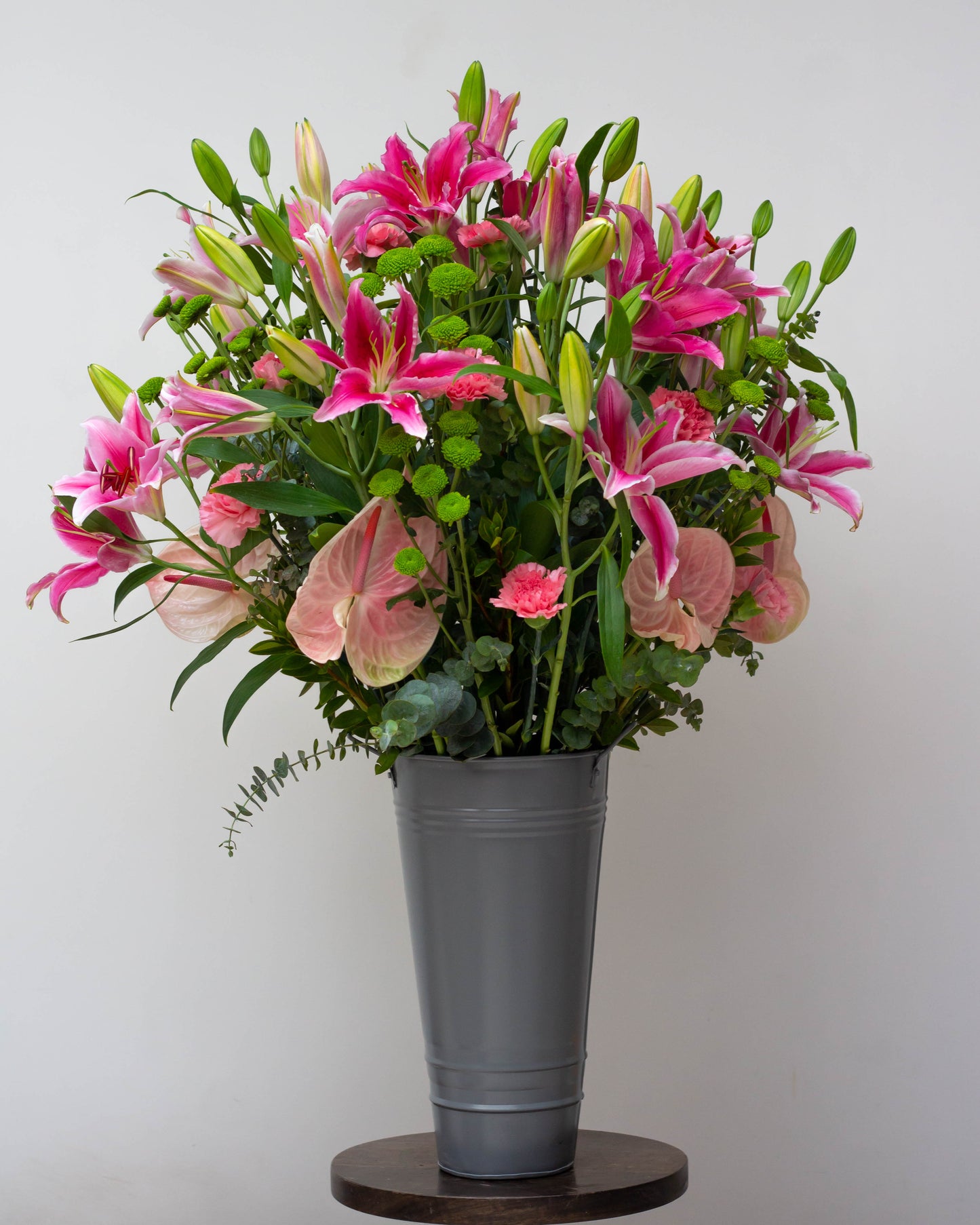 Premium flower delivery featuring a big flower bouquet in a stylish tin arrangement. This stunning bouquet includes Pink Oriental Lilies, Pink Anthuriums, Green Chrysanthemums, and Pink Carnations—perfect for online flower delivery in Bangalore, same-day florist delivery, and bouquet delivery near you. Ideal for home delivery flowers, luxury flower arrangements, and special occasions like birthdays and anniversaries. Order now for a beautiful bouquet of flowers!