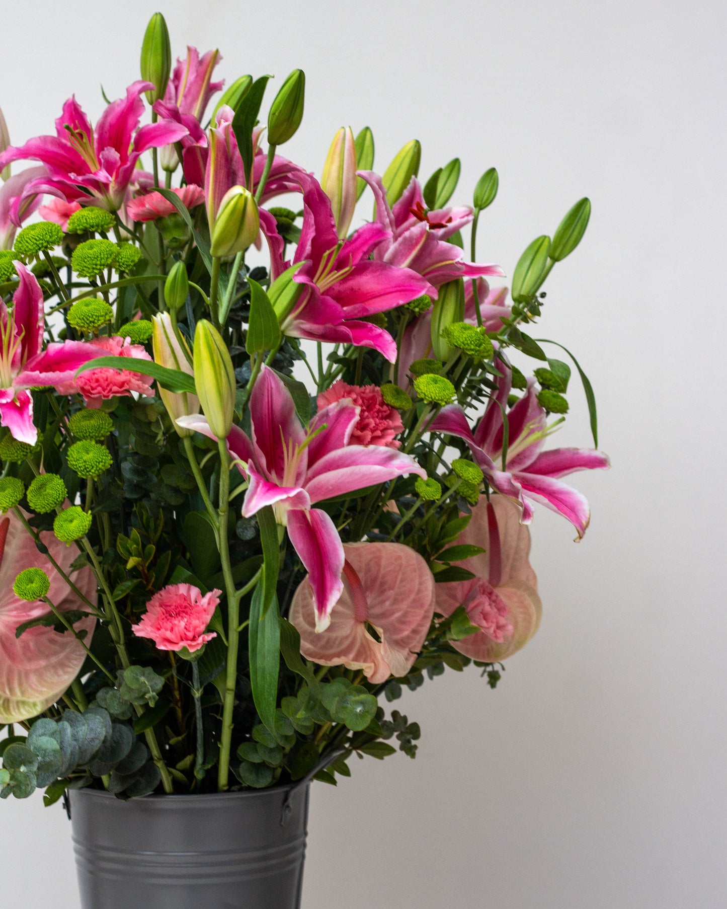Premium flower delivery featuring a big flower bouquet in a stylish tin arrangement. This stunning bouquet includes Pink Oriental Lilies, Pink Anthuriums, Green Chrysanthemums, and Pink Carnations—perfect for online flower delivery in Bangalore, same-day florist delivery, and bouquet delivery near you. Ideal for home delivery flowers, luxury flower arrangements, and special occasions like birthdays and anniversaries. Order now for a beautiful bouquet of flowers!